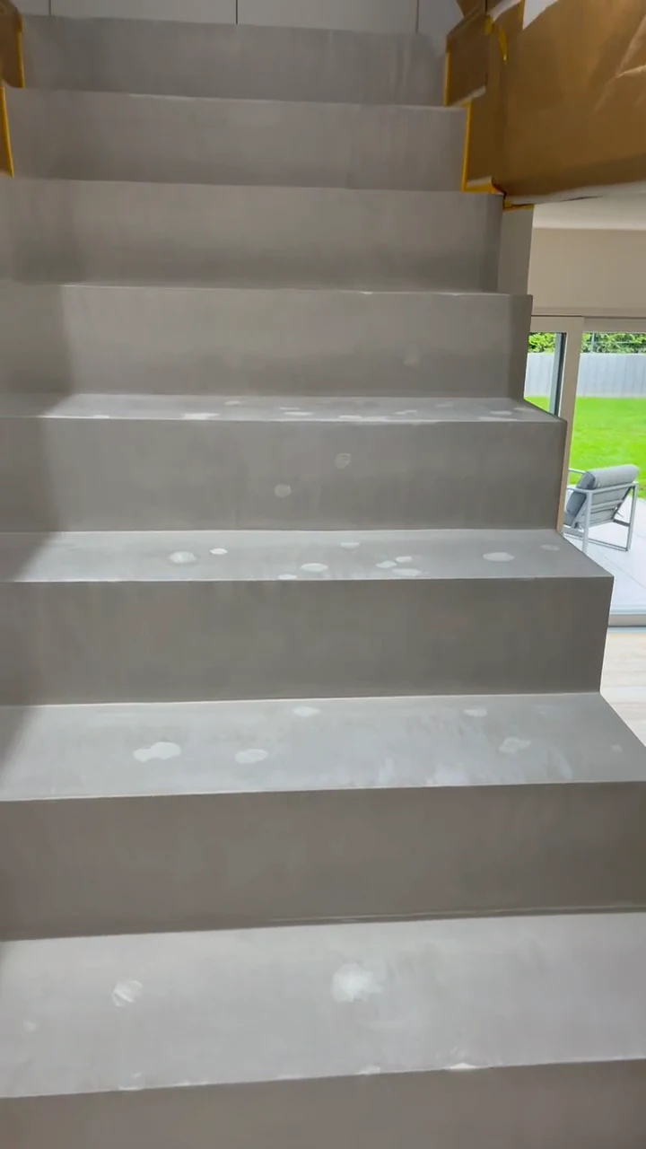 Vorher: Standbild aus dem Video, Tritte der Treppe aus Beton Ciré mit grundierten Einschlagstellen, rechts das Fenster zum Garten