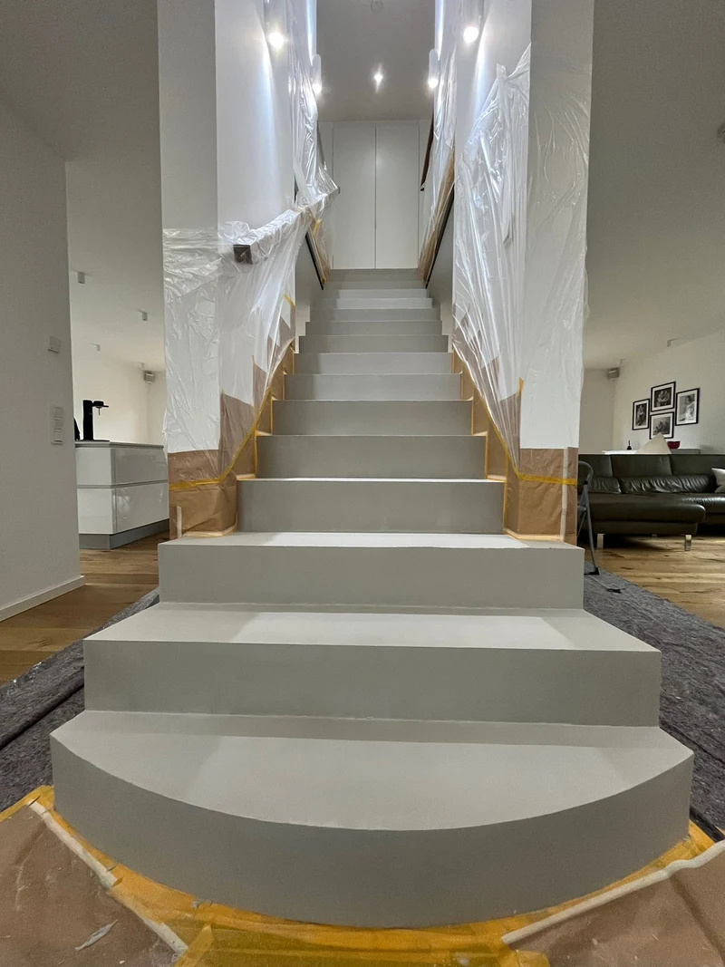 Treppe in Marl nach der ersten Lage Beton Ciré, getrocknet, Blick vom Fuß der Treppe, Boden mit Folie abgedeckt
