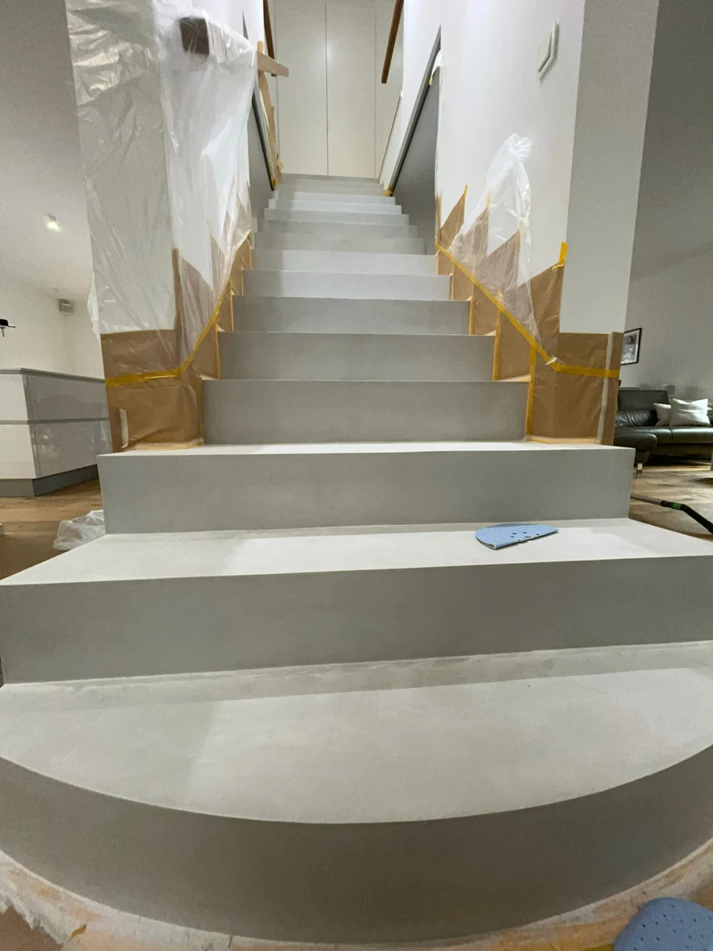 Treppe nach dem Schliff, auf einer Stufe liegt Schleifpapier für den Handschliff in den Ecken bereit