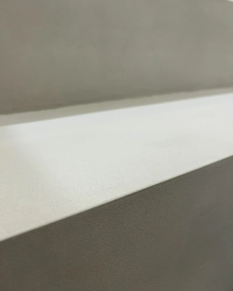Detail der fertig gespachtelten Oberfläche aus Beton Ciré an einer Stufenkante, noch ohne Versiegelung