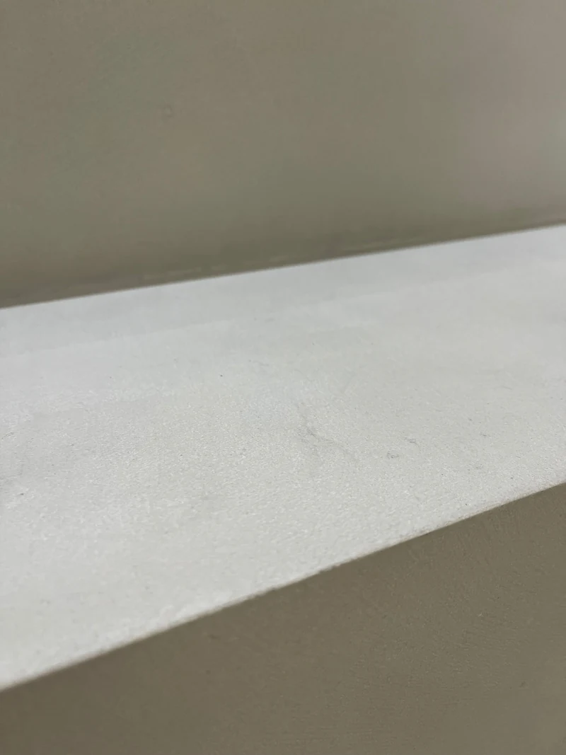 Grauton auf einer fertigen Trittstufe aus Beton Ciré aus der Nähe, versiegelte Oberfläche nach der Reparatur