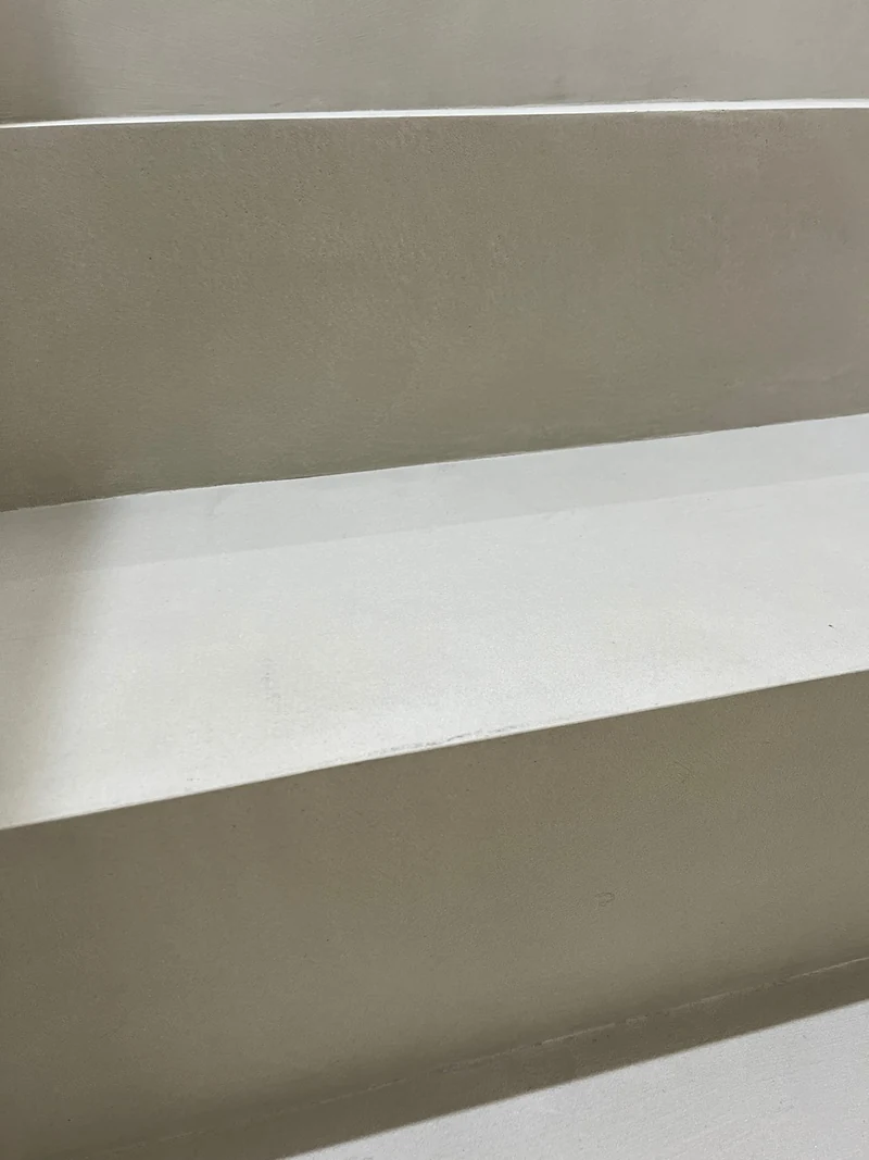 Nahaufnahme von Tritt und Stufenkante aus Beton Ciré nach der Versiegelung mit PolySealer 2K, feiner Grauton