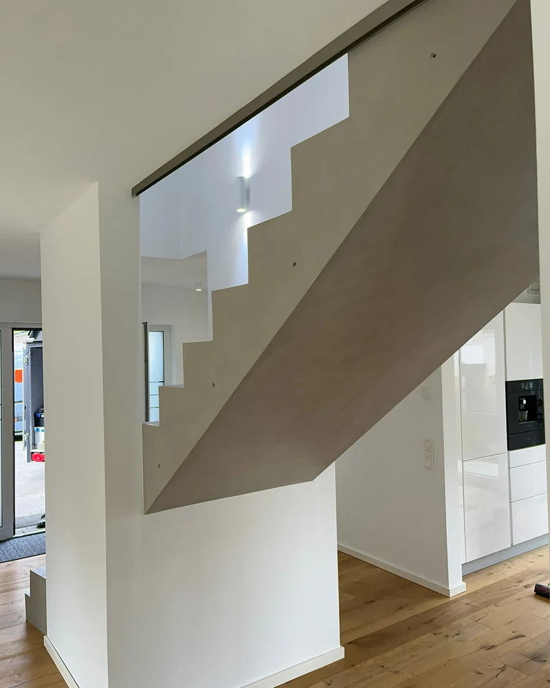 Untersicht der Treppe an der Wange mit Glasgeländer, Blick von unten in den Wohnraum, Einfamilienhaus in Marl
