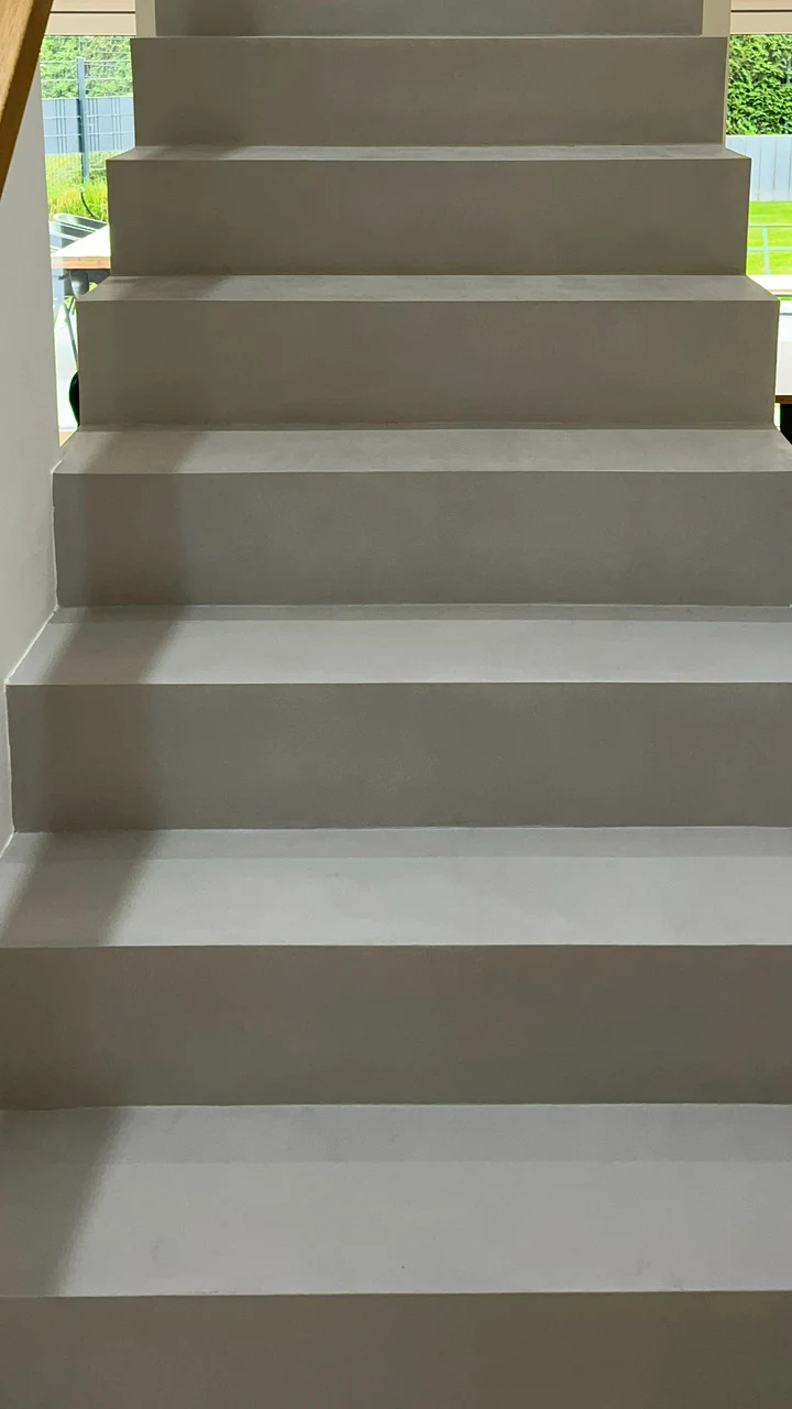 Nachher: derselbe Treppenlauf aus Beton Ciré in gleicher Blickrichtung, Tritte zweimal gespachtelt und mit PolySealer 2K versiegelt