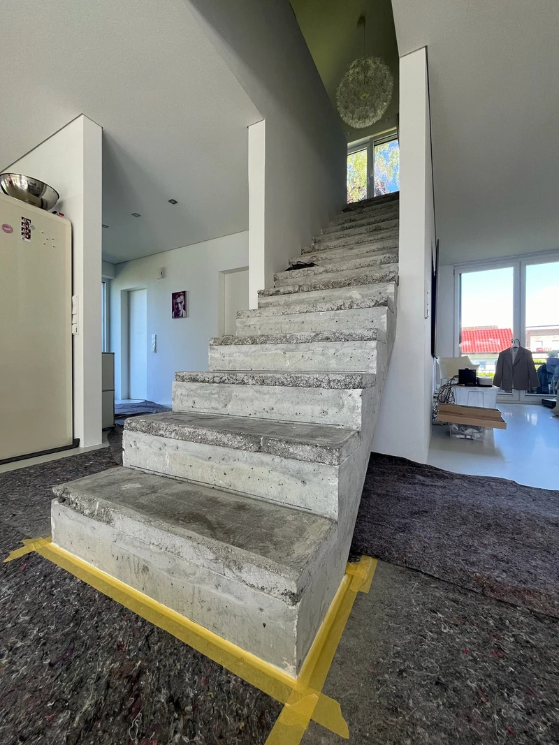 Aufbetonierte Treppe im renovierten Altbau von unten links gesehen, Boden mit Vlies abgedeckt, vor der Arbeit