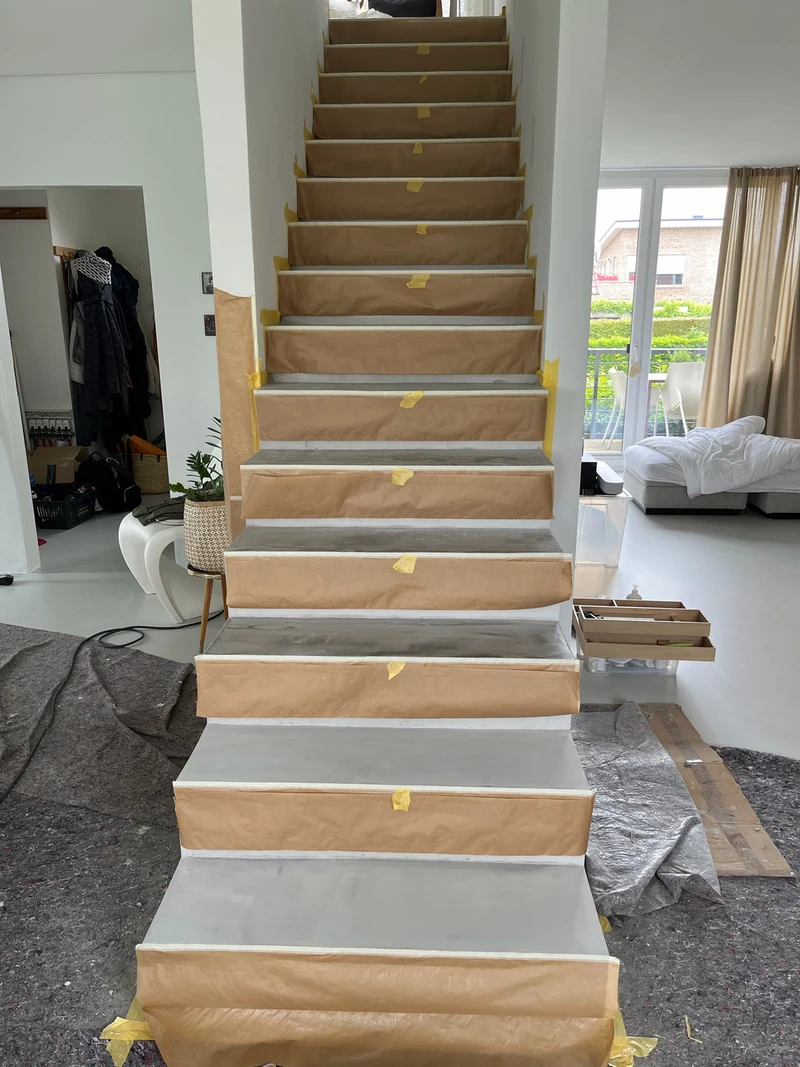 Treppe frontal mit Papier auf den Tritten, zuerst werden die Steigungen mit Splash gespachtelt, danach die Tritte