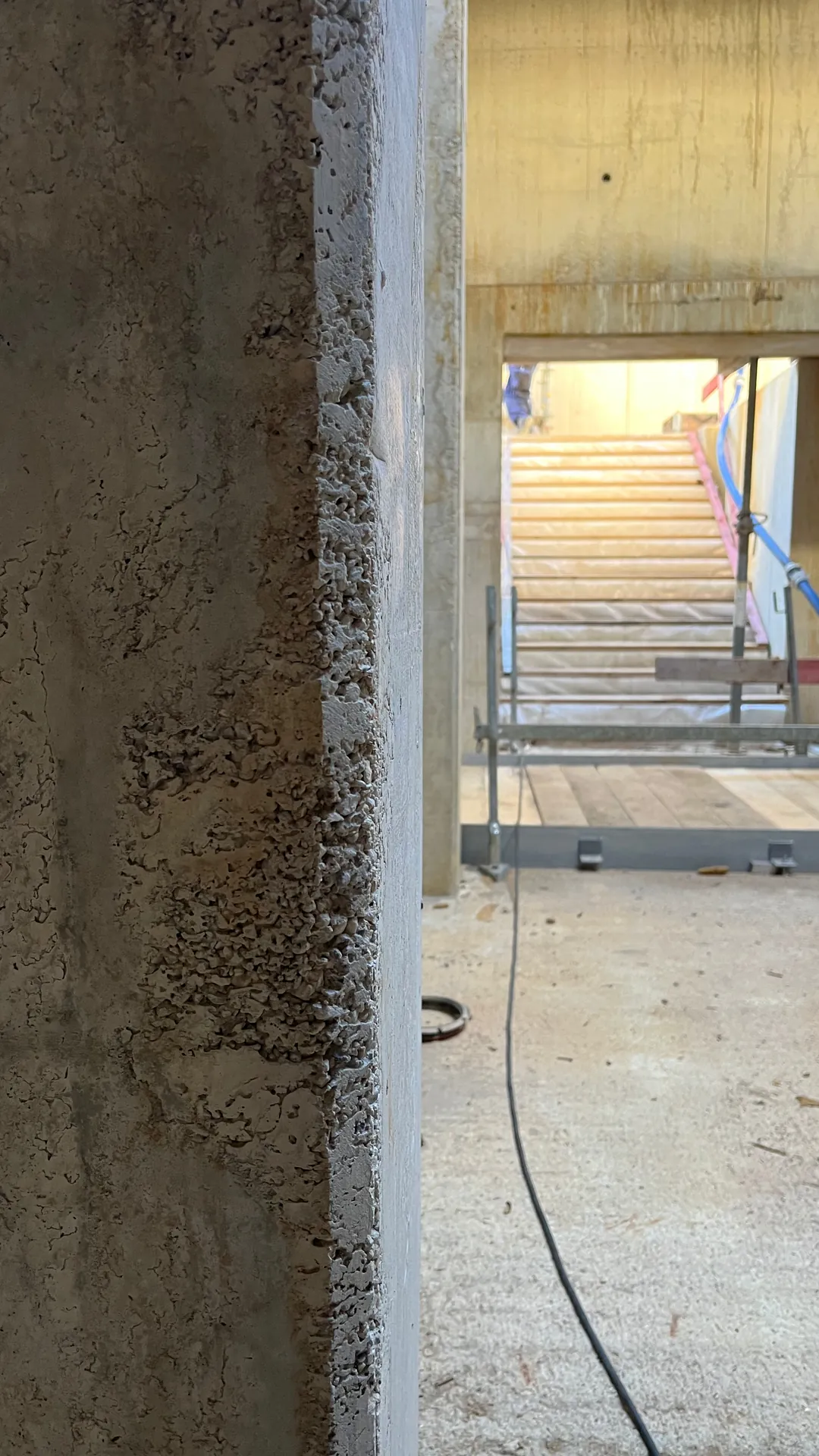 Ausgeblutete Dreikantfase an einer Sichtbetonkante im Untergeschoss vor der Betonkosmetik, poröse offene Struktur
