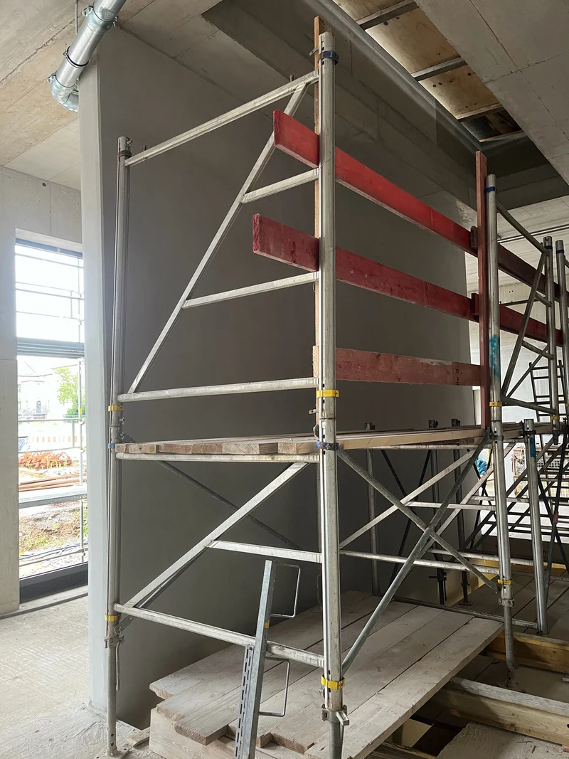 Betonfertigteil-Wandscheibe nach der Betonkosmetik mit Arbeitsgerüst davor
