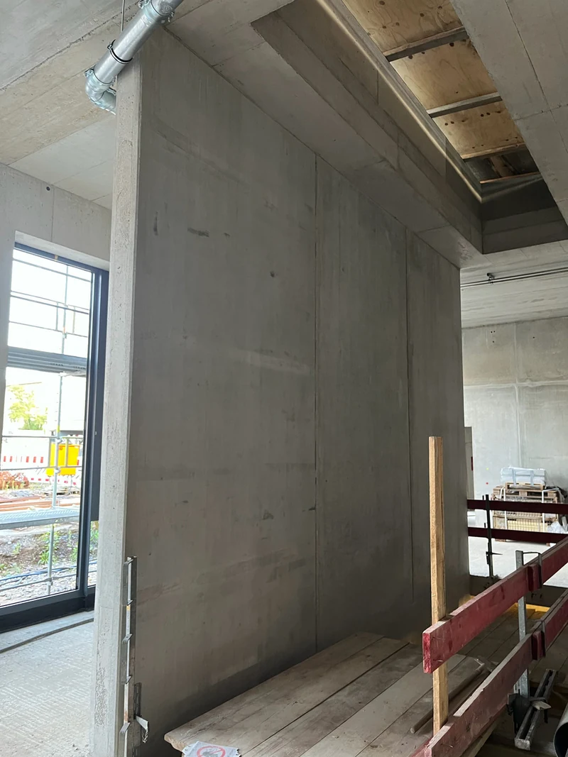 Betonfertigteil-Wandscheibe im Obergeschoss mit Lagerabdrücken, Verfärbungen und offenen Fugen, vor der Betonkosmetik