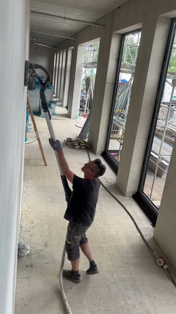 Video: Handwerker reinigt eine Betonfertigteilwand mit dem Langhalsschleifer