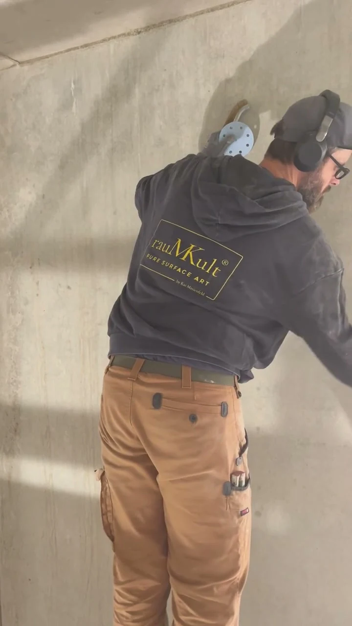 Video: Handwerker reinigt eine Betonfläche von Hand mit Schleifpapier und Schaber