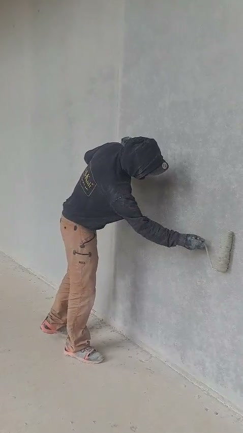 Video: Handwerker retuschiert eine Betonfertigteilwand vollflächig mit einer großen Naturschwammrolle
