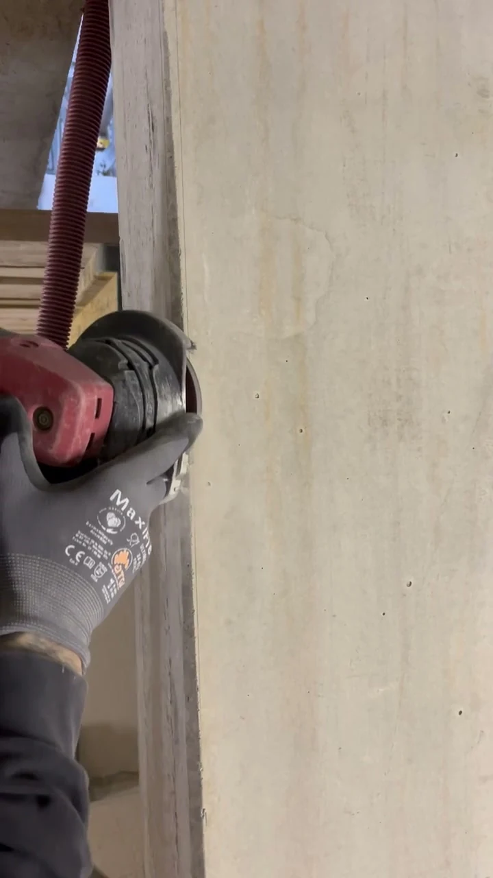 Video: Handwerker schleift mit Diamantaufsatz eine Dreikantfase an einer Betonwandscheibe
