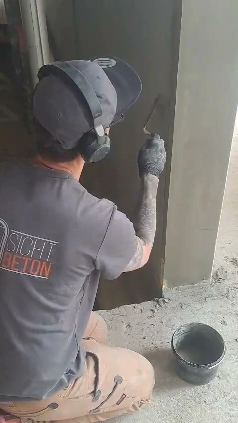 Video: Handwerker spachtelt eine Fase, Kameraschwenk auf eine gereinigte Betonwandscheibe