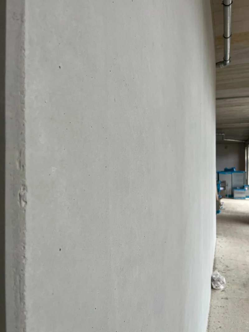 Nahaufnahme einer retuschierten Betonoberfläche von der Seite mit offenen kleinen Poren