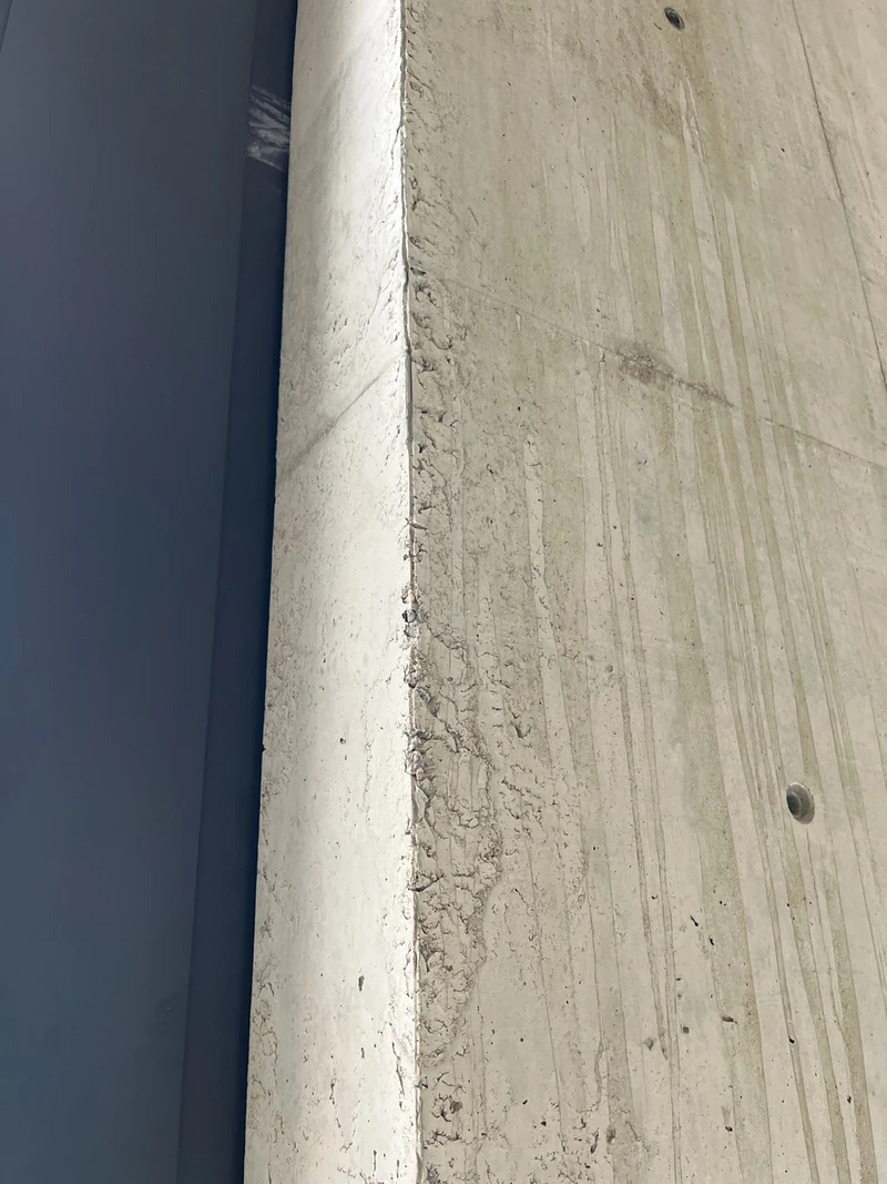 Seitenflanke einer Betonfertigteil-Wandscheibe mit Schäden, vor der Bearbeitung